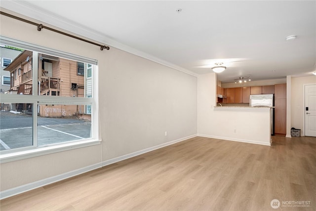 621 5th Ave N Unit 103, Seattle, WA 98109 - unfurnished living room with light wood-style floors, plenty of natural light, and crown molding