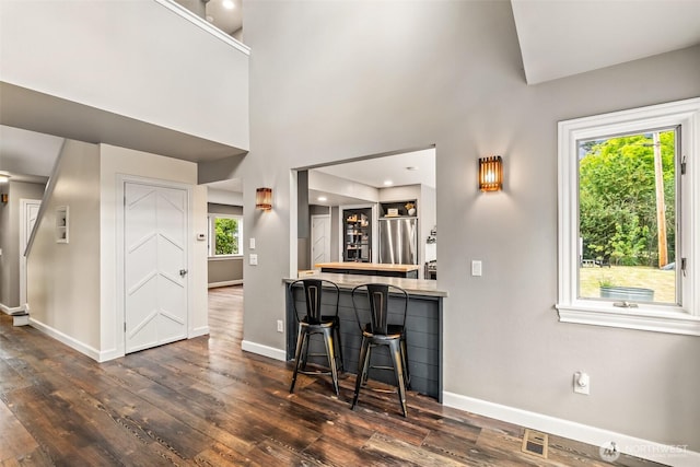 233 Joann Ln, Arlington, WA 98223 - kitchen with stainless steel fridge, wood-type flooring, and a breakfast bar area