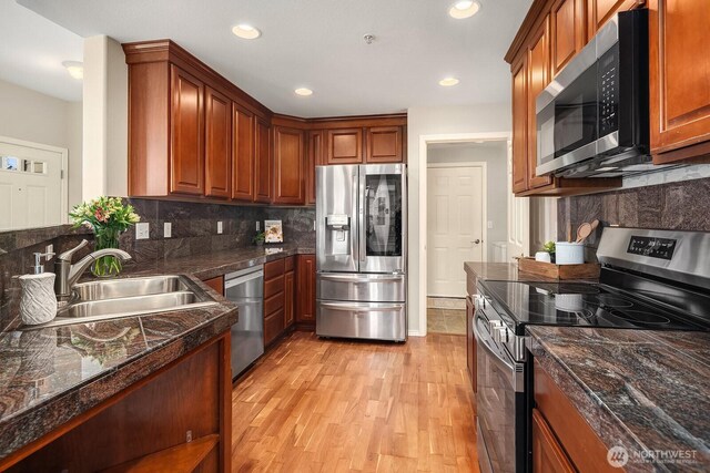 1855 Trossachs Blvd SE Unit 1401, Sammamish, WA 98075 - kitchen with appliances with stainless steel finishes, dark countertops, tasteful backsplash, light wood-style floors, and brown cabinetry