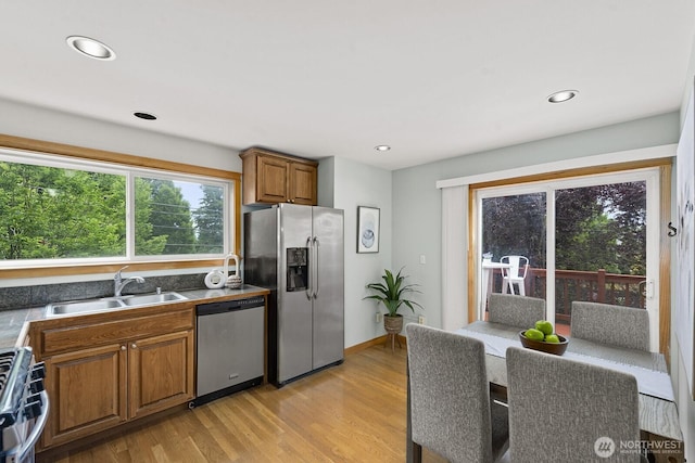 9400 35th Ave SW, Seattle, WA 98126 - kitchen with appliances with stainless steel finishes, light wood-style floors, brown cabinetry, and recessed lighting