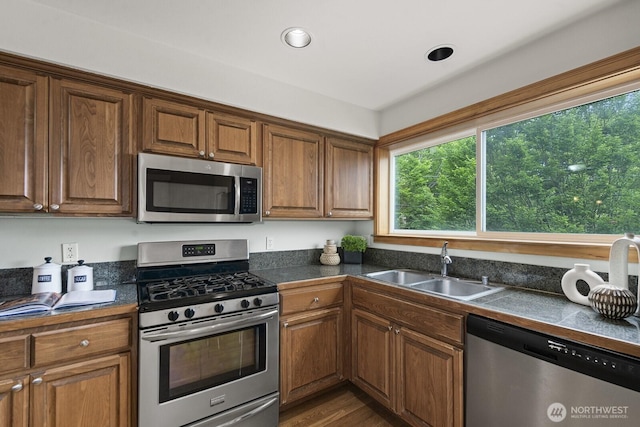 9400 35th Ave SW, Seattle, WA 98126 - kitchen with appliances with stainless steel finishes, brown cabinetry, dark wood-style flooring, and recessed lighting
