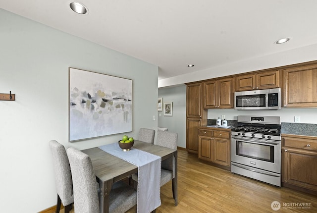 9400 35th Ave SW, Seattle, WA 98126 - kitchen featuring appliances with stainless steel finishes, light wood-style floors, recessed lighting, dark countertops, and brown cabinetry