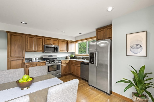 9400 35th Ave SW, Seattle, WA 98126 - kitchen featuring stainless steel appliances, light wood finished floors, brown cabinetry, and recessed lighting