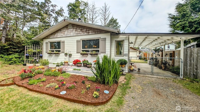 1215 273rd Pl, Ocean Park, WA 98640 - view of front facade with dirt driveway, a gate, and an attached carport