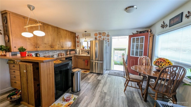 1215 273rd Pl, Ocean Park, WA 98640 - kitchen with freestanding refrigerator, brown cabinets, healthy amount of natural light, and wood finished floors