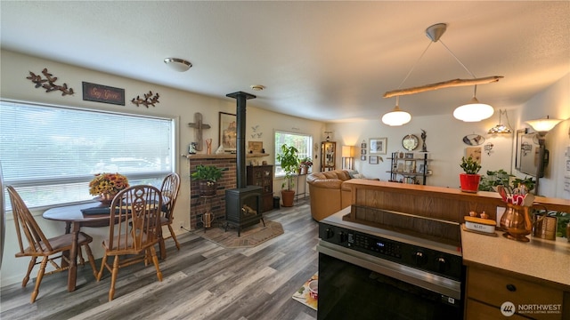 1215 273rd Pl, Ocean Park, WA 98640 - kitchen featuring stove, a wood stove, wood finished floors, and hanging light fixtures
