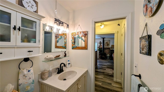 1215 273rd Pl, Ocean Park, WA 98640 - bathroom featuring vanity, wood finished floors, and a wood stove