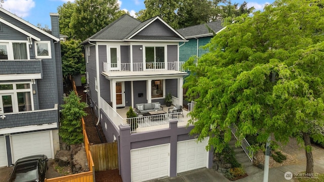 325 23rd Ave E, Seattle, WA 98112 - view of front of home featuring a balcony, an attached garage, outdoor lounge area, and driveway