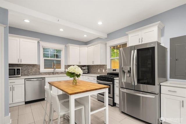 325 23rd Ave E, Seattle, WA 98112 - kitchen with appliances with stainless steel finishes, butcher block countertops, tasteful backsplash, white cabinetry, and recessed lighting