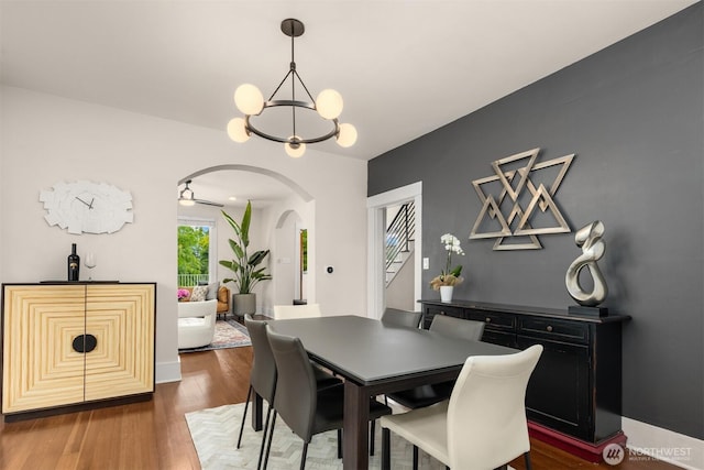 325 23rd Ave E, Seattle, WA 98112 - dining room with arched walkways, a chandelier, stairway, and wood finished floors