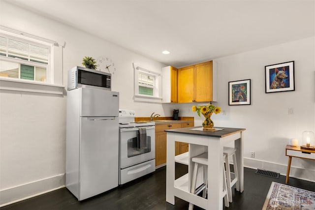 325 23rd Ave E, Seattle, WA 98112 - kitchen with white appliances, healthy amount of natural light, recessed lighting, and dark wood finished floors