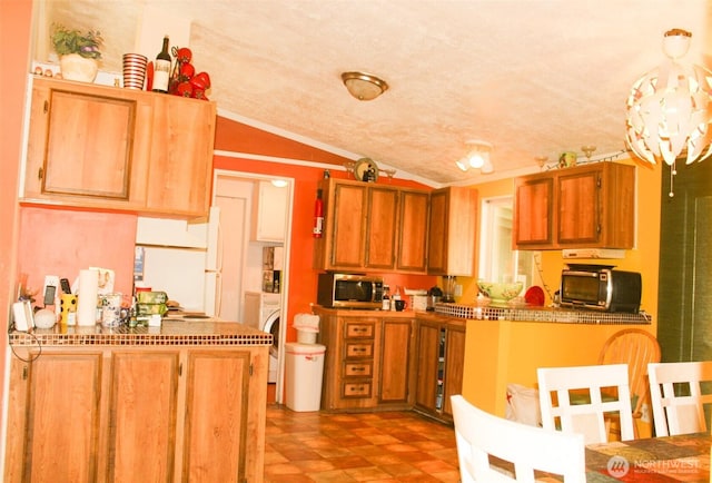 5705 Littlerock Rd SW Unit 41, Tumwater, WA 98512 - kitchen featuring stainless steel microwave, vaulted ceiling, a peninsula, washer / clothes dryer, and ornamental molding