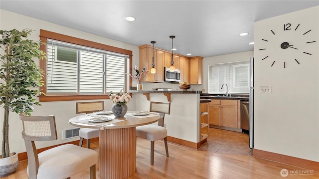 743 94th St N Unit B, Seattle, WA 98103 - kitchen with appliances with stainless steel finishes, recessed lighting, light wood-style flooring, pendant lighting, and a kitchen breakfast bar