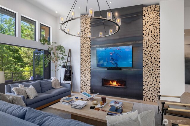 3847 Swiftwater Dr, Cle Elum, WA 98922 - living room featuring a chandelier, a glass covered fireplace, plenty of natural light, a high ceiling, and recessed lighting