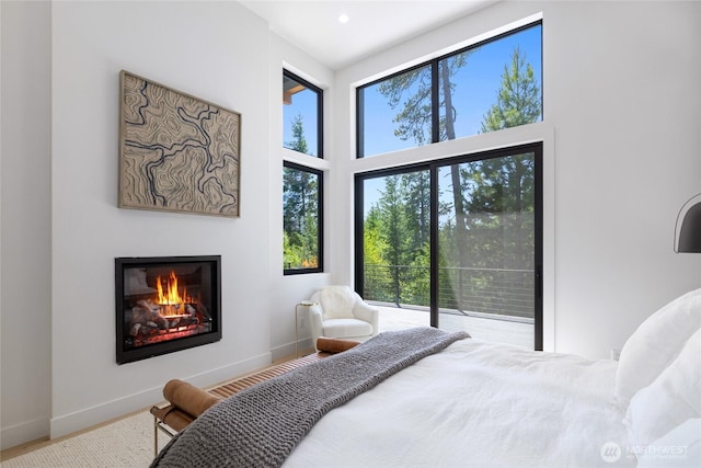 3847 Swiftwater Dr, Cle Elum, WA 98922 - bedroom with a glass covered fireplace, a towering ceiling, access to exterior, and recessed lighting