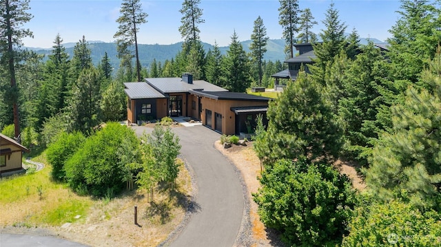 3847 Swiftwater Dr, Cle Elum, WA 98922 - view of front of house with a garage, a mountain view, asphalt driveway, a metal roof, and a chimney