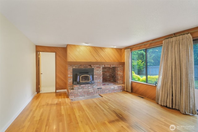 2004 SW 306th Pl, Federal Way, WA 98023 - unfurnished living room with wooden walls, light wood-type flooring, and a wood stove