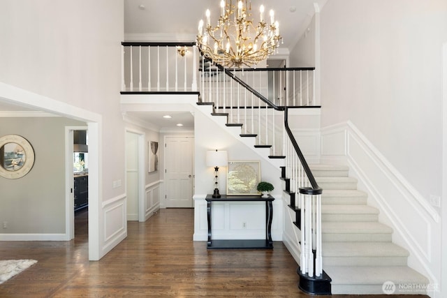 8234 NE 8th St, Medina, WA 98039 - stairs featuring a high ceiling, wood finished floors, a chandelier, ornamental molding, and a decorative wall