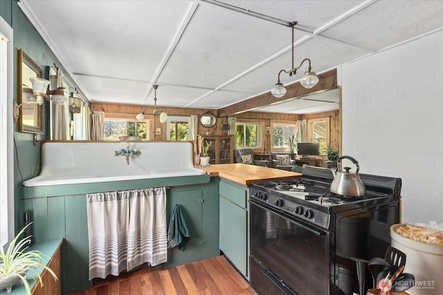 48911 Mountain Loop Hwy, Granite Falls, WA 98252 - kitchen with black range with gas stovetop, wood finished floors, green cabinetry, and butcher block countertops