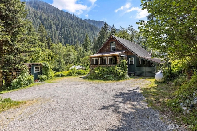 48911 Mountain Loop Hwy, Granite Falls, WA 98252 - rustic home featuring a forest view, gravel driveway, a shed, and a metal roof