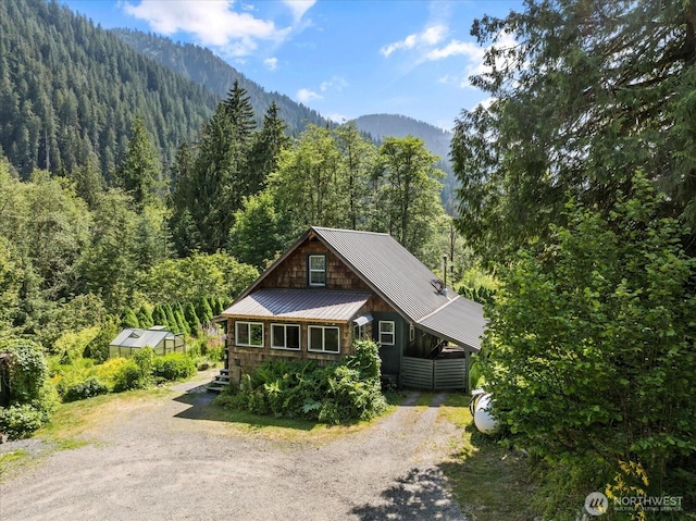 48911 Mountain Loop Hwy, Granite Falls, WA 98252 - view of front of house featuring a wooded view, dirt driveway, a metal roof, and a mountain view