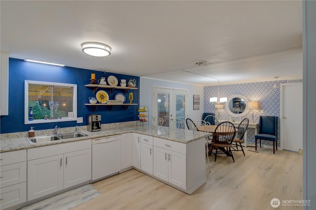 1411 297th Ln, Ocean Park, WA 98640 - kitchen with white dishwasher, light wood-type flooring, open shelves, french doors, and white cabinetry