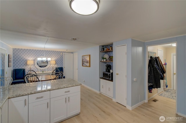 1411 297th Ln, Ocean Park, WA 98640 - kitchen with light wood finished floors, white cabinets, a chandelier, light stone countertops, and crown molding