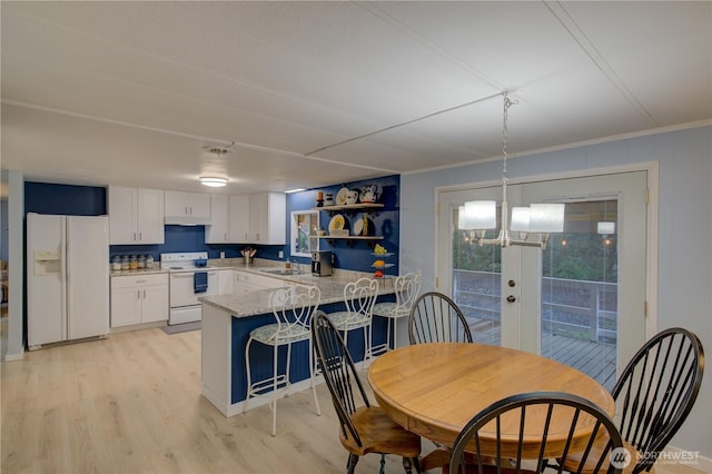 1411 297th Ln, Ocean Park, WA 98640 - kitchen with white appliances, a peninsula, white cabinets, light wood finished floors, and a chandelier