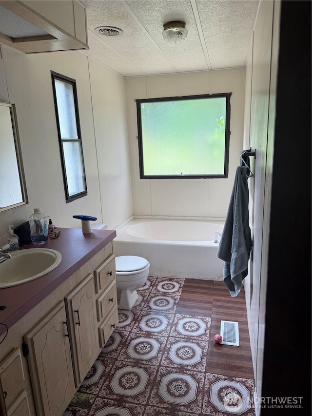 14307 215th Ave E, Bonney Lake, WA 98391 - bathroom with a bathtub, vanity, a textured ceiling, and wood finished floors