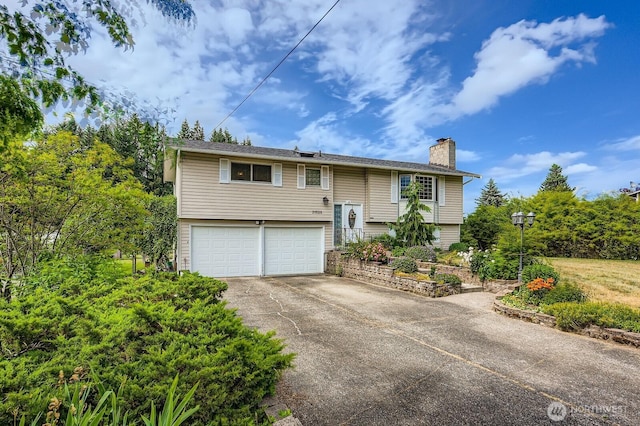 21520 36th Avenue Ct E, Spanaway, WA 98387 - split foyer home with a chimney, concrete driveway, and a garage