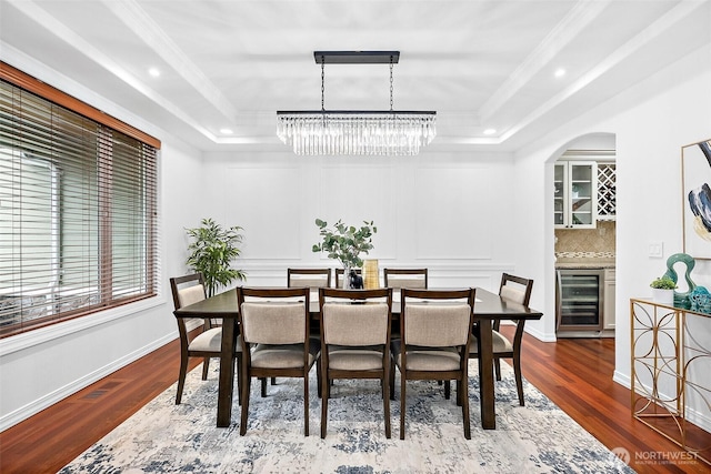 1402 180th Ave E, Lake Tapps, WA 98391 - dining area featuring beverage cooler, a raised ceiling, a chandelier, wood finished floors, and ornamental molding