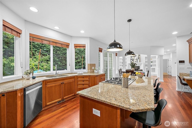 1402 180th Ave E, Lake Tapps, WA 98391 - kitchen with stainless steel appliances, a kitchen bar, wood finished floors, brown cabinets, and recessed lighting