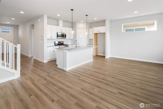 544 SW 97th St Unit 5, Seattle, WA 98106 - kitchen featuring appliances with stainless steel finishes, tasteful backsplash, white cabinets, light wood-type flooring, and recessed lighting
