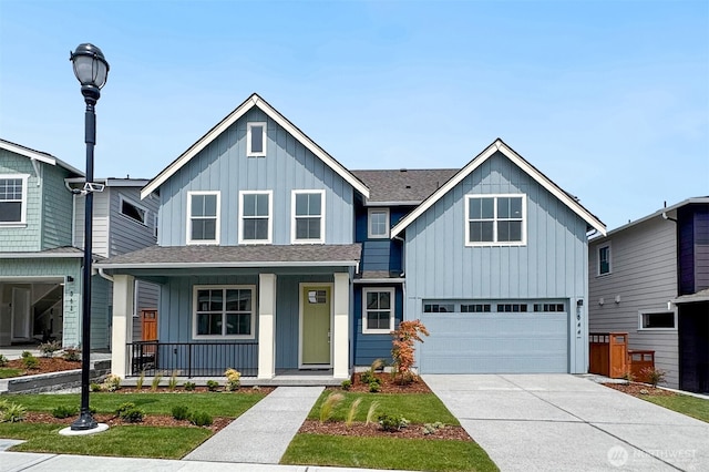 544 SW 97th St Unit 5, Seattle, WA 98106 - view of front of property with board and batten siding, covered porch, a garage, roof with shingles, and driveway