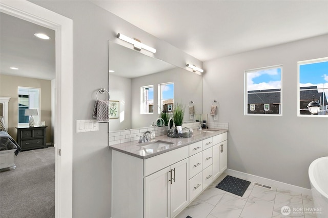 9898 5th Ln SW Unit 23, Seattle, WA 98106 - ensuite bathroom with double vanity, recessed lighting, a freestanding tub, and marble finish flooring