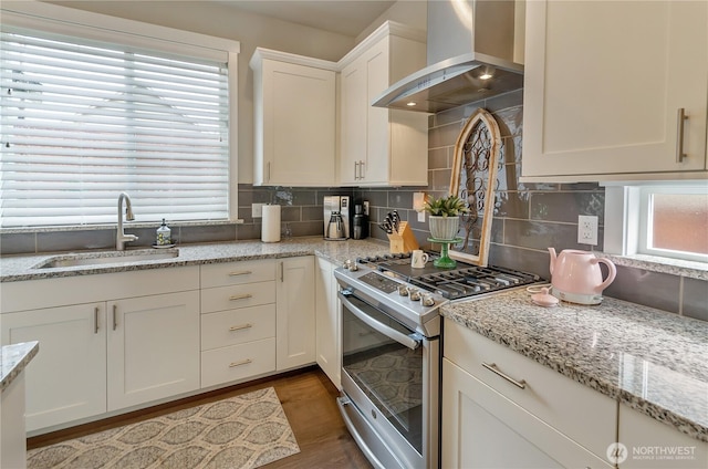 24220 93rd Ct S, Kent, WA 98030 - kitchen with stainless steel gas stove, wall chimney exhaust hood, tasteful backsplash, wood finished floors, and white cabinetry