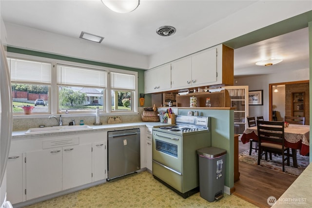 308 2nd Ave, Harrington, WA 99134 - kitchen featuring stainless steel dishwasher, white range, light countertops, and white cabinetry