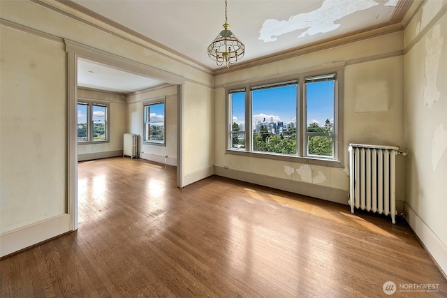 1902 Bigelow Ave N Unit 301, Seattle, WA 98109 - empty room with radiator, ornamental molding, wood finished floors, and a chandelier