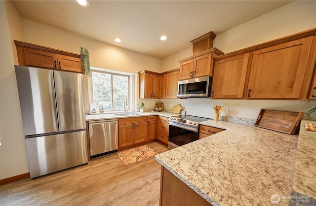 121 Stafford St, Leavenworth, WA 98826 - kitchen with appliances with stainless steel finishes, light wood-style flooring, brown cabinetry, recessed lighting, and light stone counters