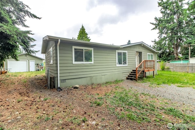 8715 Whitewood Loop SE, Yelm, WA 98597 - rear view of house featuring a detached garage and an outdoor structure