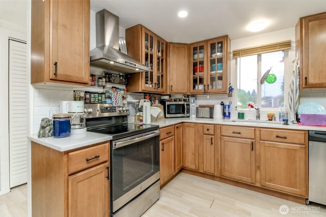8715 Whitewood Loop SE, Yelm, WA 98597 - kitchen featuring wall chimney range hood, stainless steel appliances, light countertops, and light wood finished floors