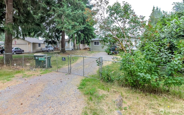 8715 Whitewood Loop SE, Yelm, WA 98597 - view of property hidden behind natural elements with a gate and driveway