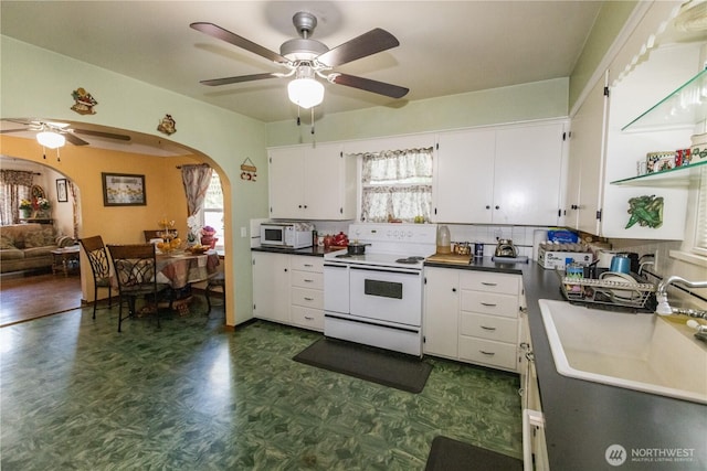 1107 S 4th St, Dayton, WA 99328 - kitchen with white appliances, arched walkways, a ceiling fan, and dark flooring