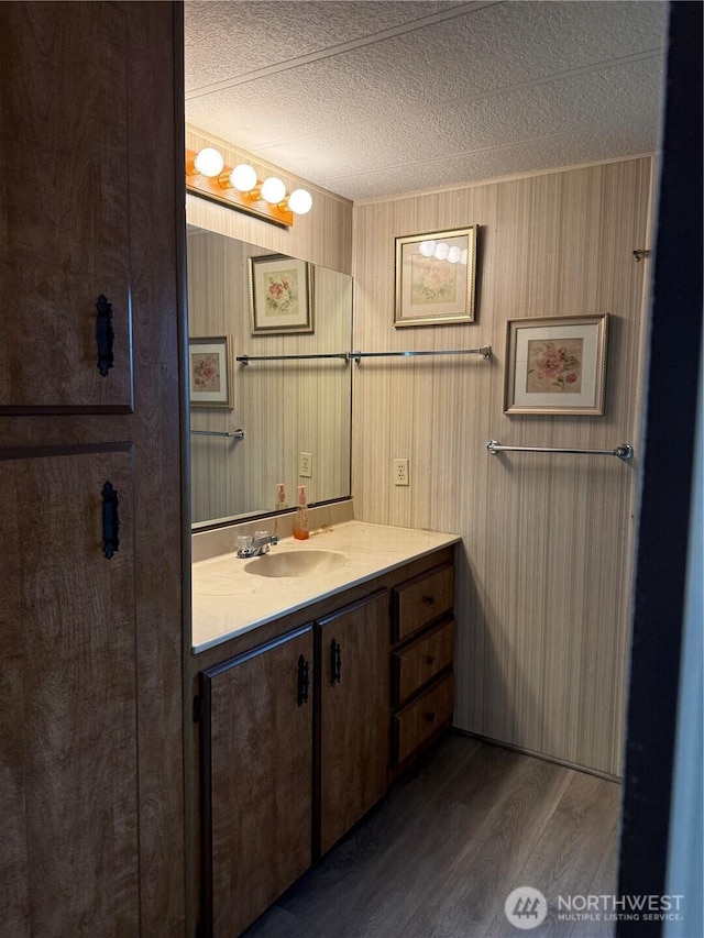 2308 Ventura Ave, Enumclaw, WA 98022 - bathroom featuring wood finished floors, vanity, a textured ceiling, and wooden walls