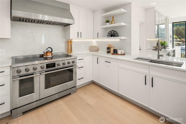 101 101st Ave SE Unit 201A, Bellevue, WA 98004 - kitchen with wall chimney exhaust hood, range with two ovens, light countertops, and open shelves