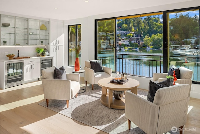 101 101st Ave SE Unit 201A, Bellevue, WA 98004 - living area featuring wine cooler, light wood-style flooring, wet bar, a water view, and recessed lighting