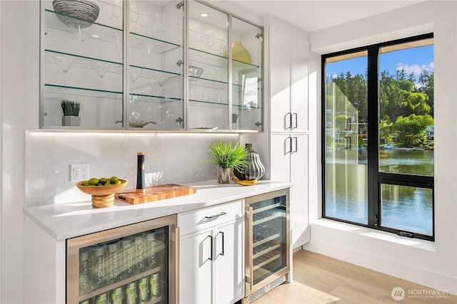 101 101st Ave SE Unit 201A, Bellevue, WA 98004 - indoor dry bar with wine cooler, light wood-type flooring, and a water view