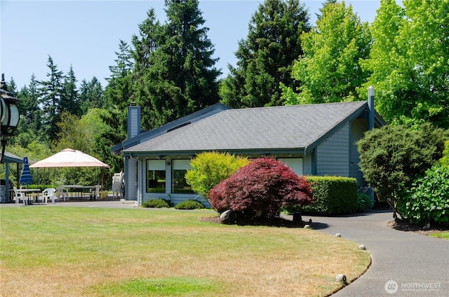 4018 144th Street Ct NW Unit 59, Gig Harbor, WA 98332 - view of side of property featuring a yard, a chimney, and roof with shingles