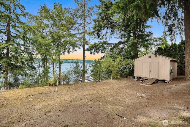 1711 E Lake Sammamish Pl SE, Sammamish, WA 98075 - yard at dusk featuring a shed and a water view