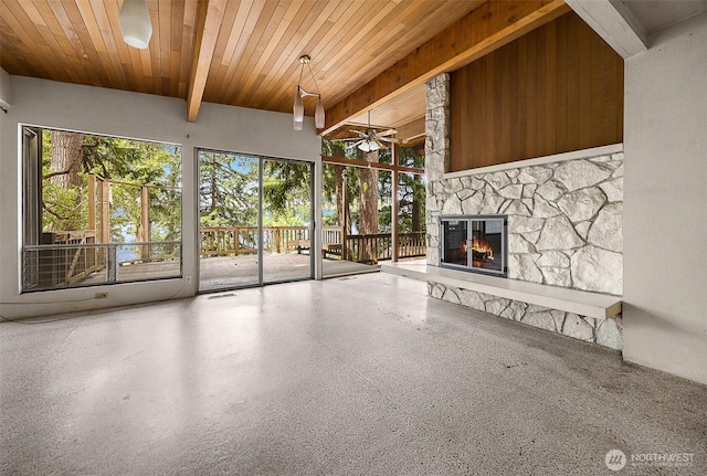 1711 E Lake Sammamish Pl SE, Sammamish, WA 98075 - unfurnished living room with ceiling fan, a stone fireplace, plenty of natural light, speckle patterned floor, and a wood ceiling with exposed beams